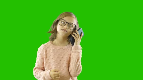 Piccola bella ragazza circa dieci dodici con gli occhiali che parlano al telefono, emozioni — Video Stock