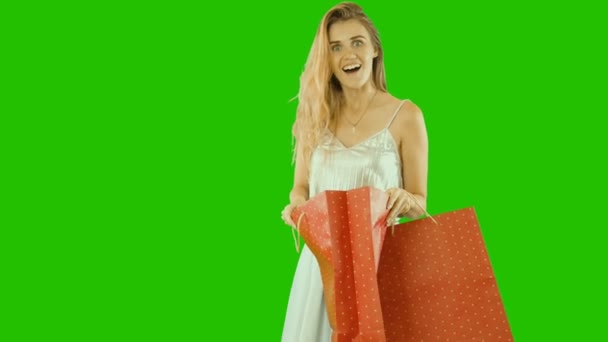 Attractive girl in a perennial dress with blond long hair holding packages with gifts in her hands is smiling and looking into packages, Christmas gifts — Stock Video