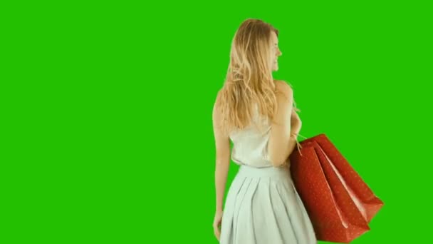 Attractive girl with blond long hair holds bags in her hands and smiles playfully, Christmas gifts, Christmas presents — Stock Video