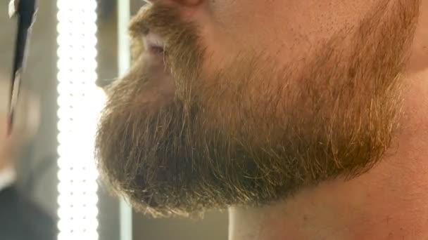 Крупним планом, як чоловік коригує вуса і бороду ножицями — стокове відео