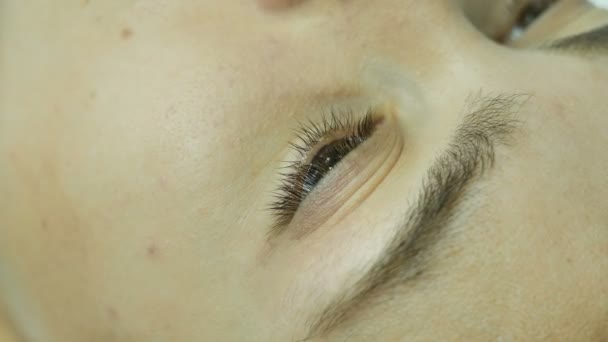 Schönheitssalon Meister in schwarzen Handschuhen legt eine Schablone auf die Augen der Kunden, Nahaufnahme Mädchen Wimpern, Verfahren im Wellness-Salon — Stockvideo