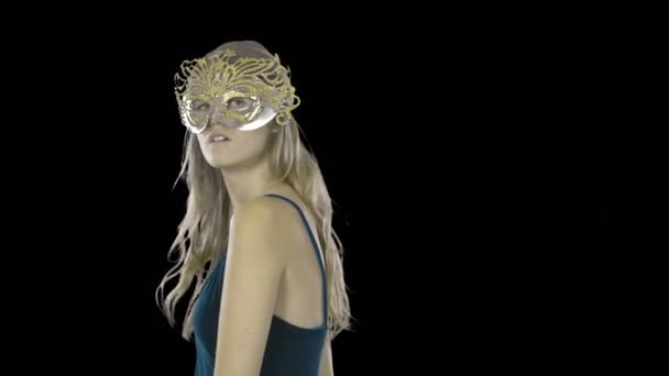 Young beautiful woman with long hair in evening dress and masquerade mask shows mystery and modesty smiling, shooting on an isolated background — Stock Video