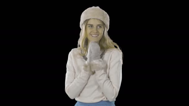 Blond woman elegantly dressed in a hat and mittens folded doloni is touched and leads her eyes around, smiles emotionally and shows the class with both hands, shooting on an isolated background — Stock Video