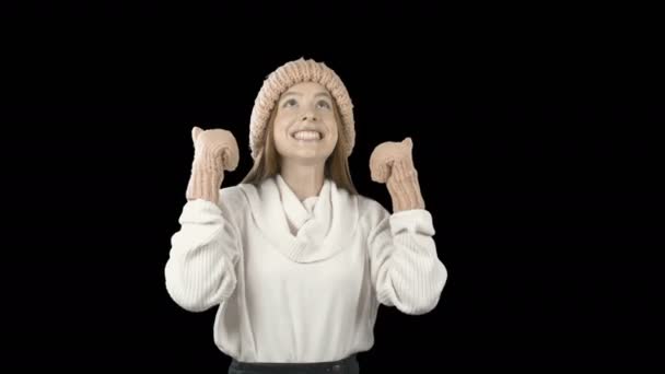 Hermosa joven con el pelo rojo largo en un sombrero de punto y mitones con gran entusiasmo y felicidad irreprimible muestra filmación de clase sobre un fondo aislado — Vídeo de stock