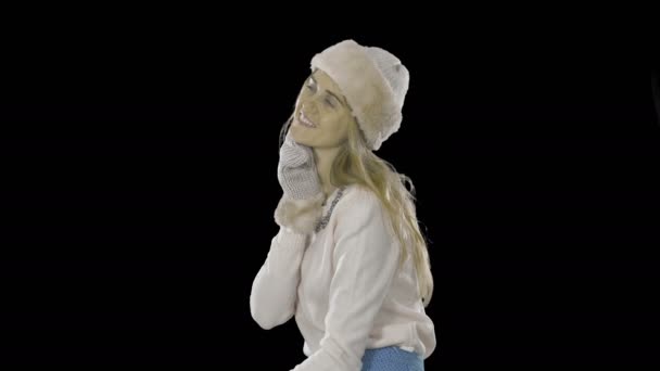 Elegante schöne junge Frau mit Hut, Fäustlingen und einem Pullover mit bestickten Steinen am Hals zeigt etwas glücklich lächelndes Träume, Modefotografie auf einem isolierten Hintergrund — Stockvideo