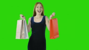 Izole yeşil arka plan üzerinde alışveriş yaptıktan sonra kağıt torbaile kırmızı saçlı mutlu kız Portresi