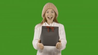 Noel ve Yeni Yıl için elinde bir hediye ile kızıl avrupalı mutlu genç kız Portresi. Sadaka ile uğraşan.