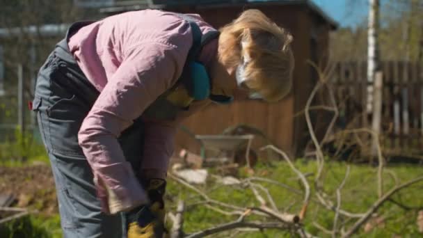 Femme d'âge moyen coupant des branches de hache — Video