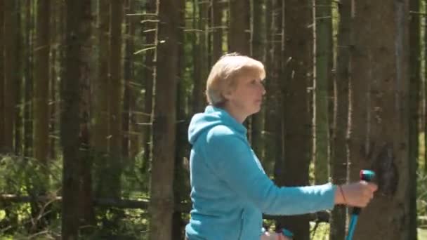 Nő sétál túrázó póznák — Stock videók