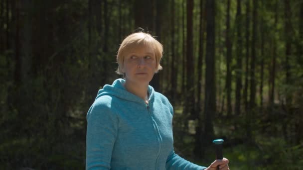 Portret van volwassen blonde vrouw tegen het bos — Stockvideo
