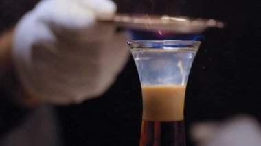 Barmen üzerine tarçın serpiştiriyor.