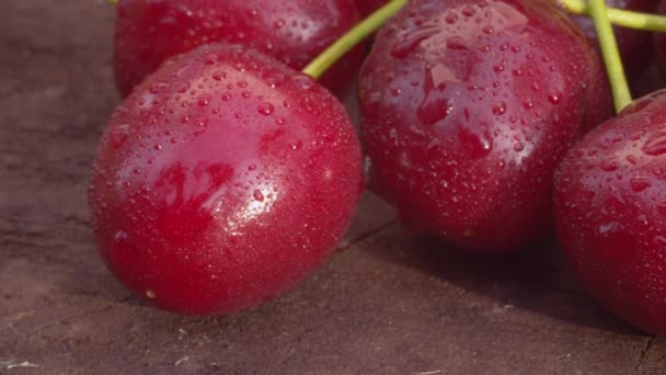 用水滴把成熟的樱桃封闭在木板上 宏观拍摄 相机缓慢地沿着浆果滑块移动 夏季新鲜健康食品 — 图库视频影像