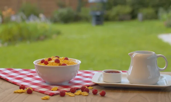 Schüssel Mit Cornflakes Mit Himbeere Und Milchkrug Auf Dem Tisch — Stockfoto