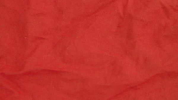 Aşırı yakın çekim - kırmızı keten kumaş. Doku, tekstil arka planı. Makro çekim, kamera yavaşça kaydırakta kumaş üzerinde hareket ediyor..