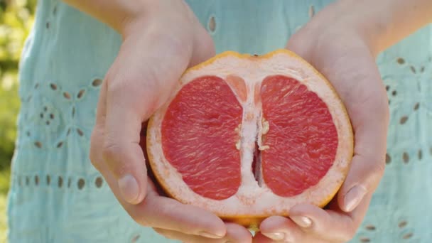Grapefruit jumătate în mâinile femeilor — Videoclip de stoc