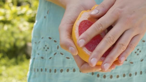 Grapefrukt hälften i kvinnliga händer — Stockvideo