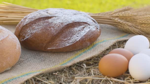 Хлеб и куриные яйца на свежем сене — стоковое видео