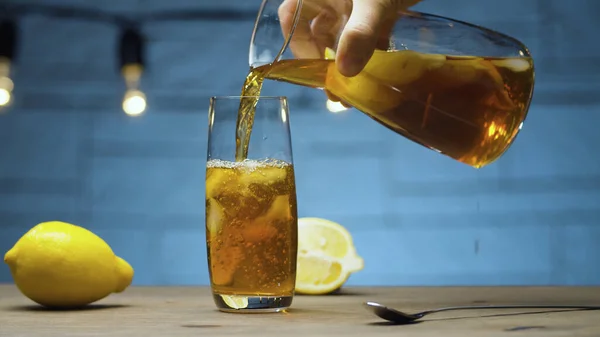 Close Male Hand Pouring Ice Tea Glass Blurry Lamps Blue — Stock Photo, Image