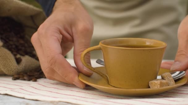Hände legen eine Tasse Kaffee hin — Stockvideo