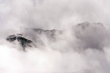 Dramatik dağ manzarası ile teleferik teleferik ve sis