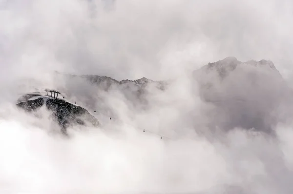 Dramatic mountain landscape with cable car gondola and fog