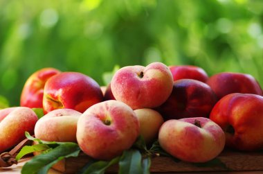 olgun şeftali ve yapraklar masada