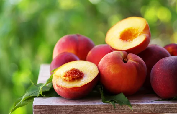 ripe peaches and slices on table