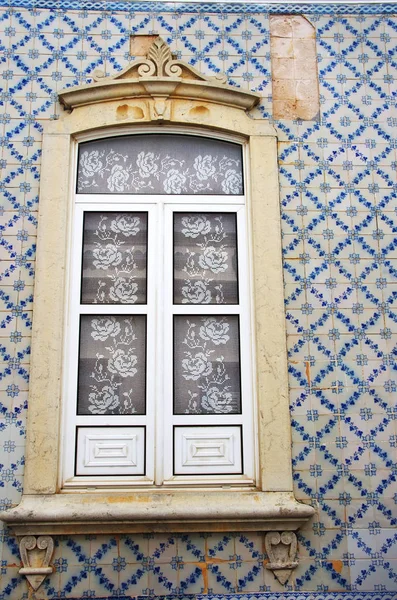 Португальское окно на покрашенной плиткой стене — стоковое фото
