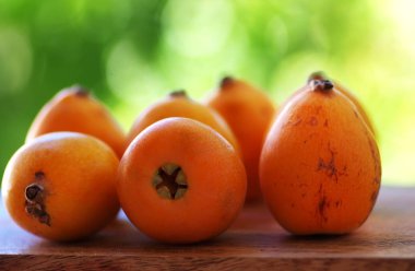 Ahşap bir masada loquat meyveleri