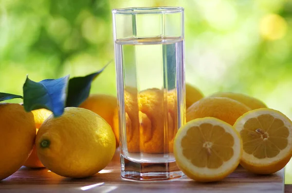 Acqua di vetro con limone isolato sullo sfondo verde — Foto Stock