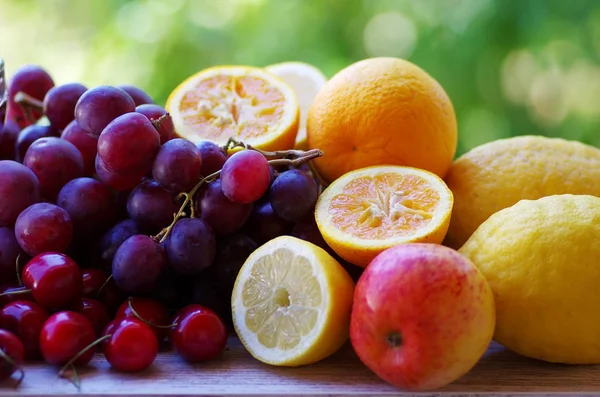 Frutas cítricas, cerezas y uvas en la mesa — Foto de Stock