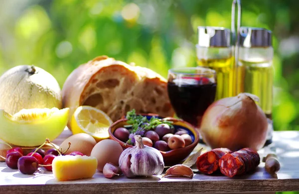 Carne, brea e vinho, especiarias e frutas na mesa — Fotografia de Stock