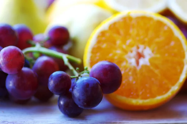 Hrozny a plátky oranžového ovoce — Stock fotografie