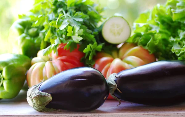 Два баклажана и овощи на столе — стоковое фото