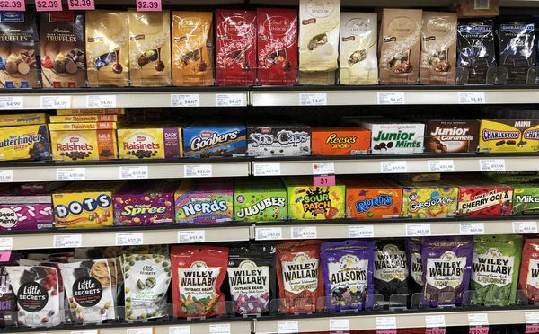 Mehrere Süßigkeitenverpackungen im Regal eines modernen Lebensmittelgeschäfts — Stockfoto