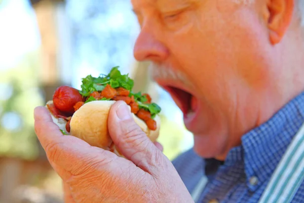 Hombre Comiendo Perrito Caliente Cubierto Con Chile Lechuga Picada — Foto de Stock