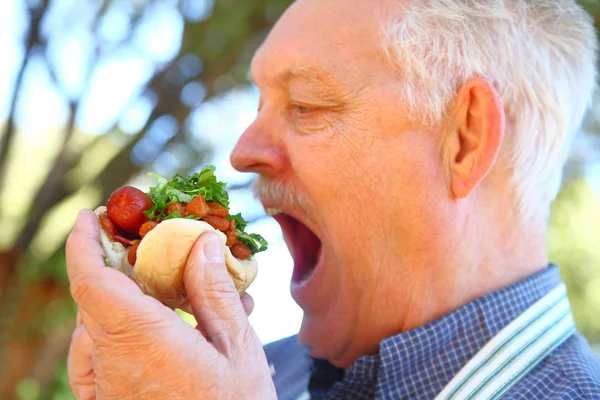 Muž Zástěře Připravené Zakousnutí Hot Dog Chilli Sekané Salát — Stock fotografie