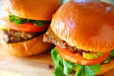 İki köfteli sandviç börek çörek marul, domates ve turşu ile üzerinde closeup