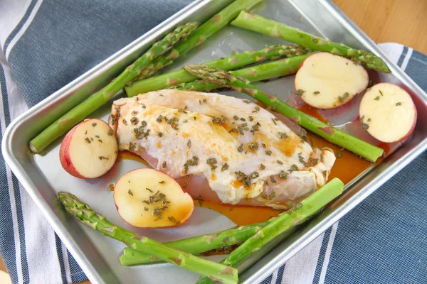 Chicken breast on half sheet pan with asparagus and small red potatoe