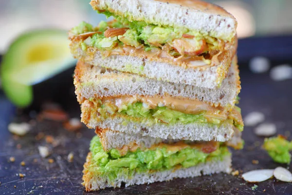 Tercios Apilados Mantequilla Cacahuete Puré Bocadillo Aguacate Con Almendras Rodajas —  Fotos de Stock