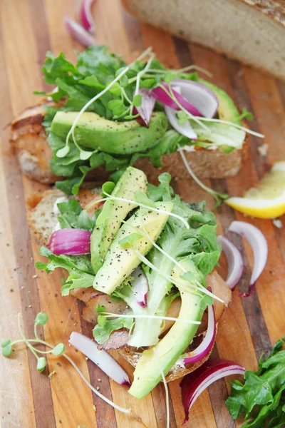 Vista Vertical Sándwiches Salmón Ahumado Con Aguacate Cebollas Brotes Tabla —  Fotos de Stock