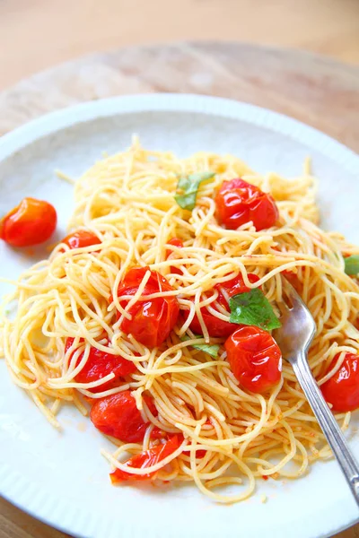 Cherry tomatoes cooked in olive oil and garlic over pasta