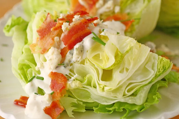 Wedge of lettuce with blue cheese dressing and bacon