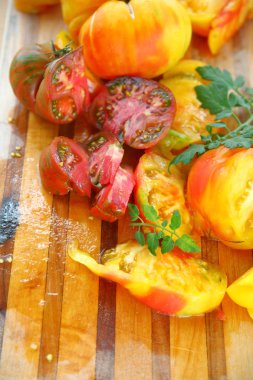 Bir kesme tahtası üzerinde taze, olgun domates suları ile dikey görünüm