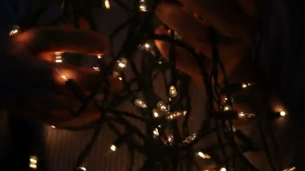 Ένας Άντρας Προσπαθεί Ξετυλίξει Τις Χορδές Των Χριστουγεννιάτικων Φώτων — Αρχείο Βίντεο