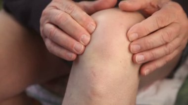 Bir adam dirseğindeki ağrıyı kontrol eder..