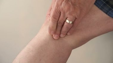 Bir adam dirseğindeki ağrıyı kontrol eder..