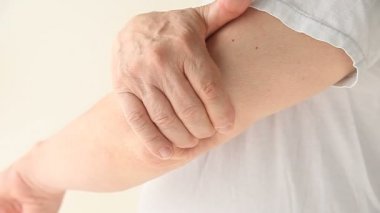 Bir adam dirseğindeki ağrıyı kontrol eder..