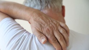 Kıdemli bir adam sırtındaki bir noktayı kaşımaya çalışıyor.