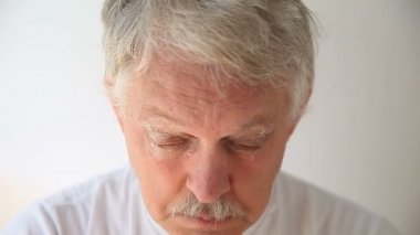 Yaşlı bir adam kirpiklerini ve kaşlarını tahriş edici olmayan bir sabunla temizler.